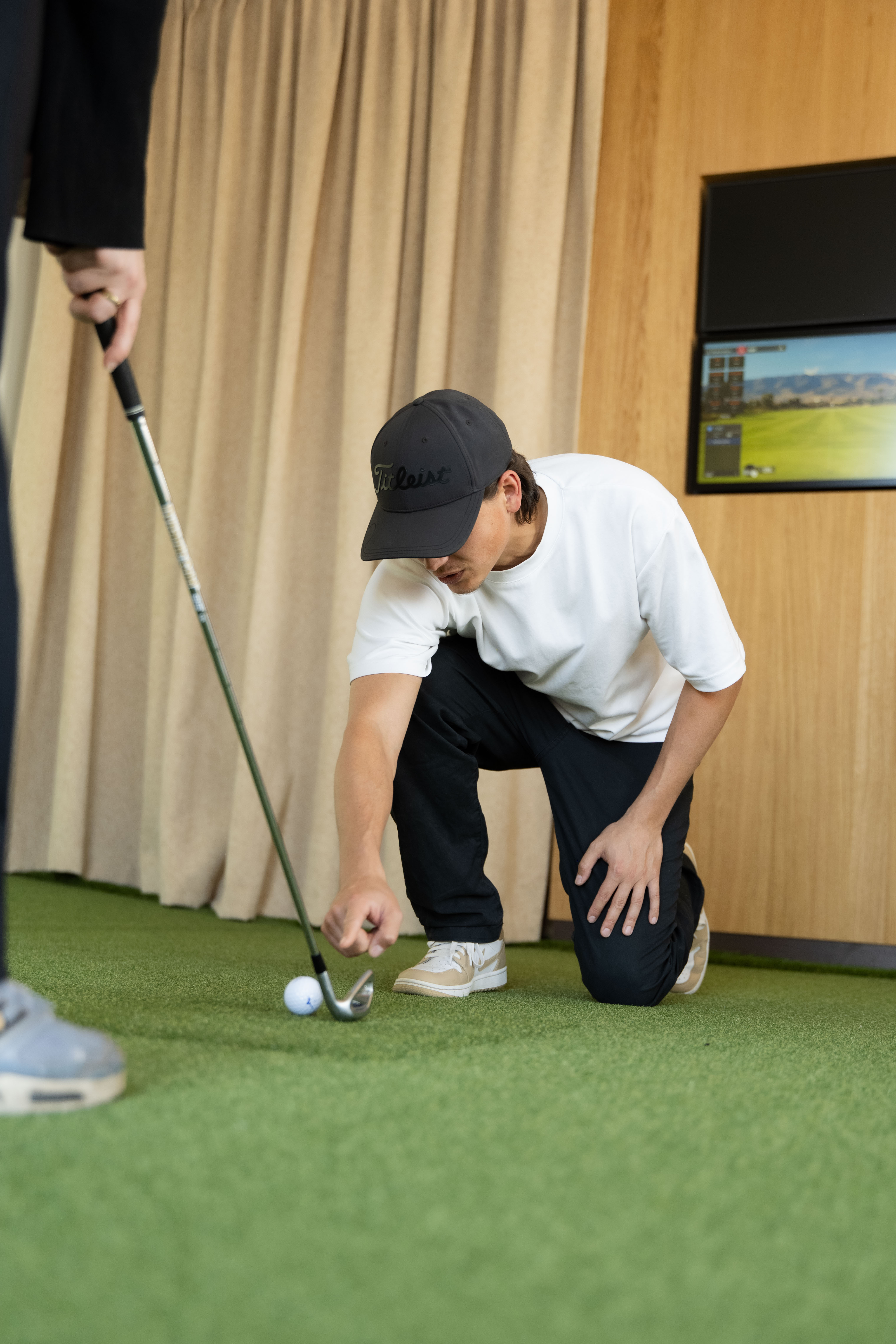 TrackMan iO golf simulator technology at Flight Golf.
Golf teacher points to golf ball.