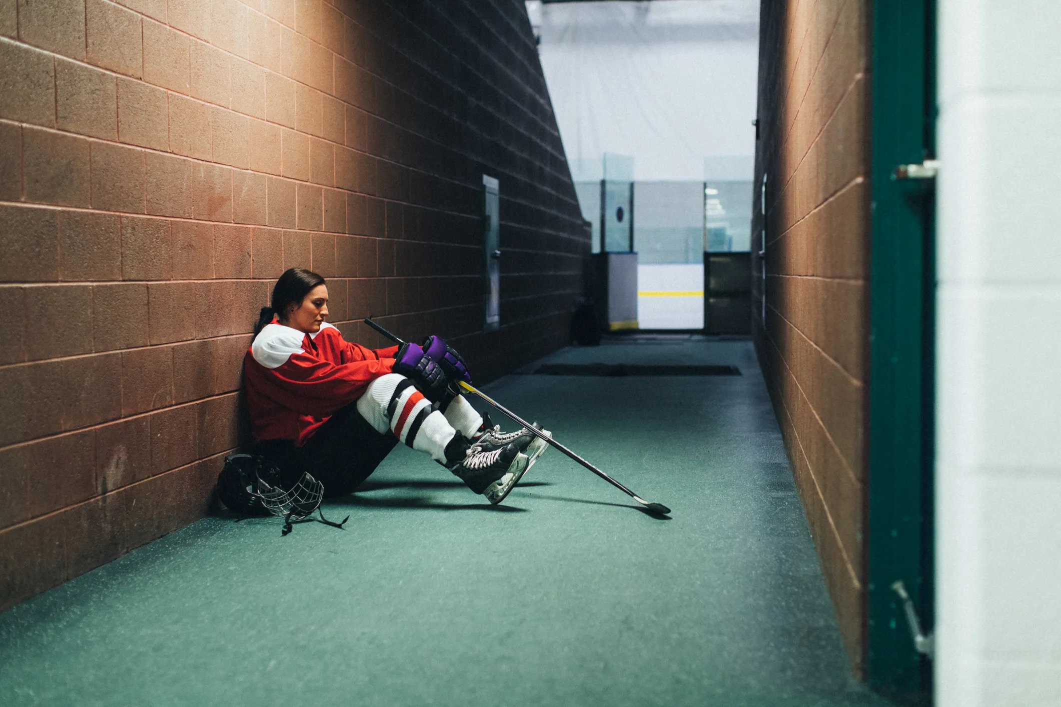 Hockey player sitting on the ground with their head down