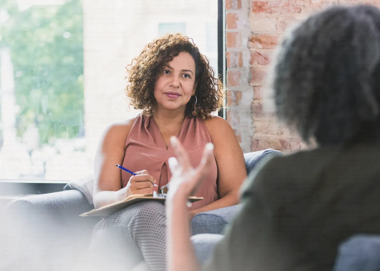 therapist and client in a session, focus on therapist face listening to client. 