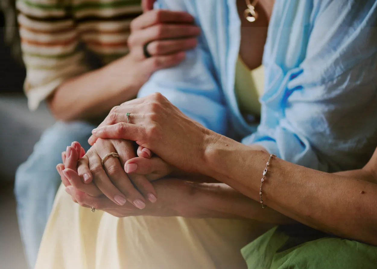 people holding hands in a supportive embrace. 
