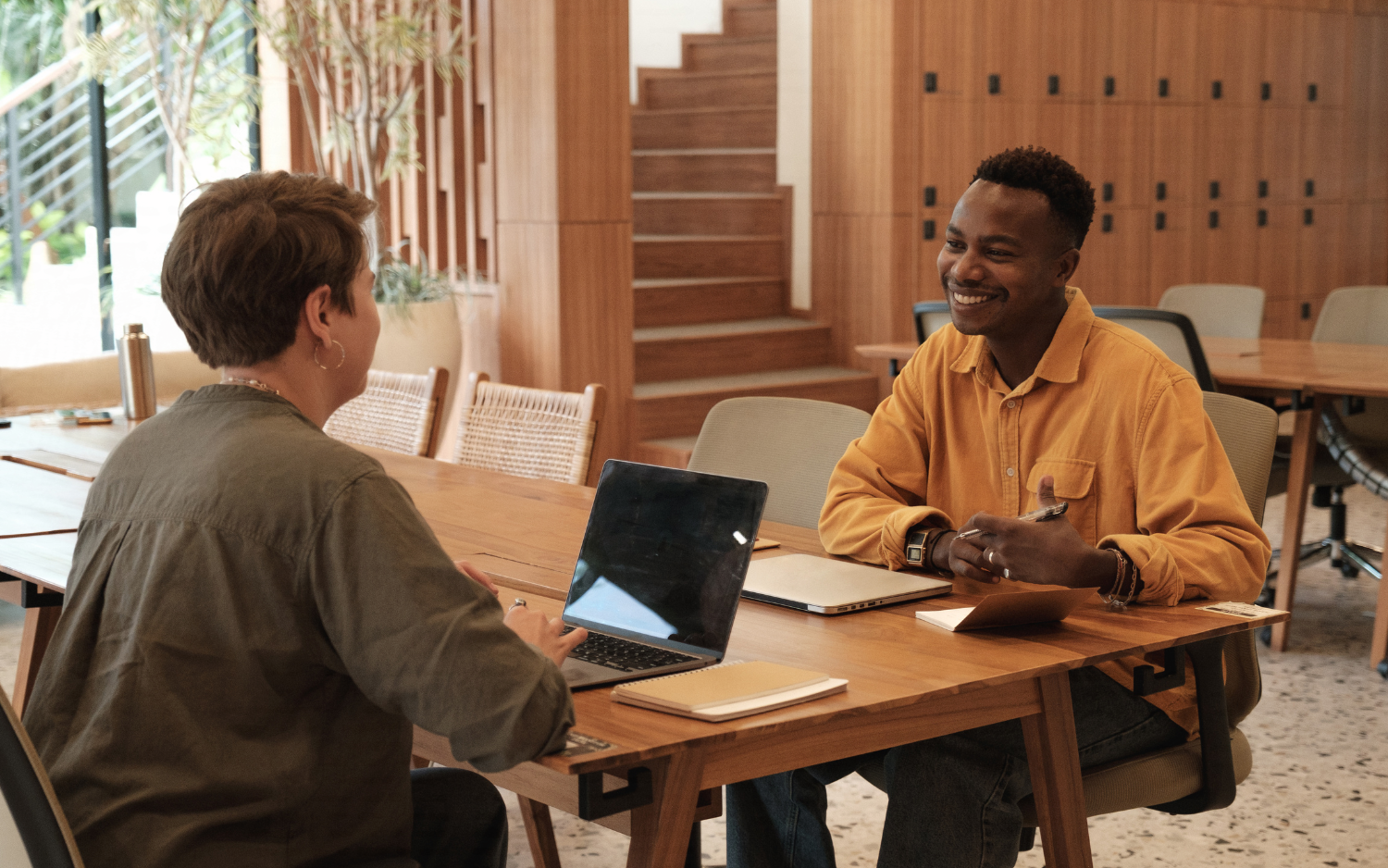 Two co-workers sitting across from each other at work. 