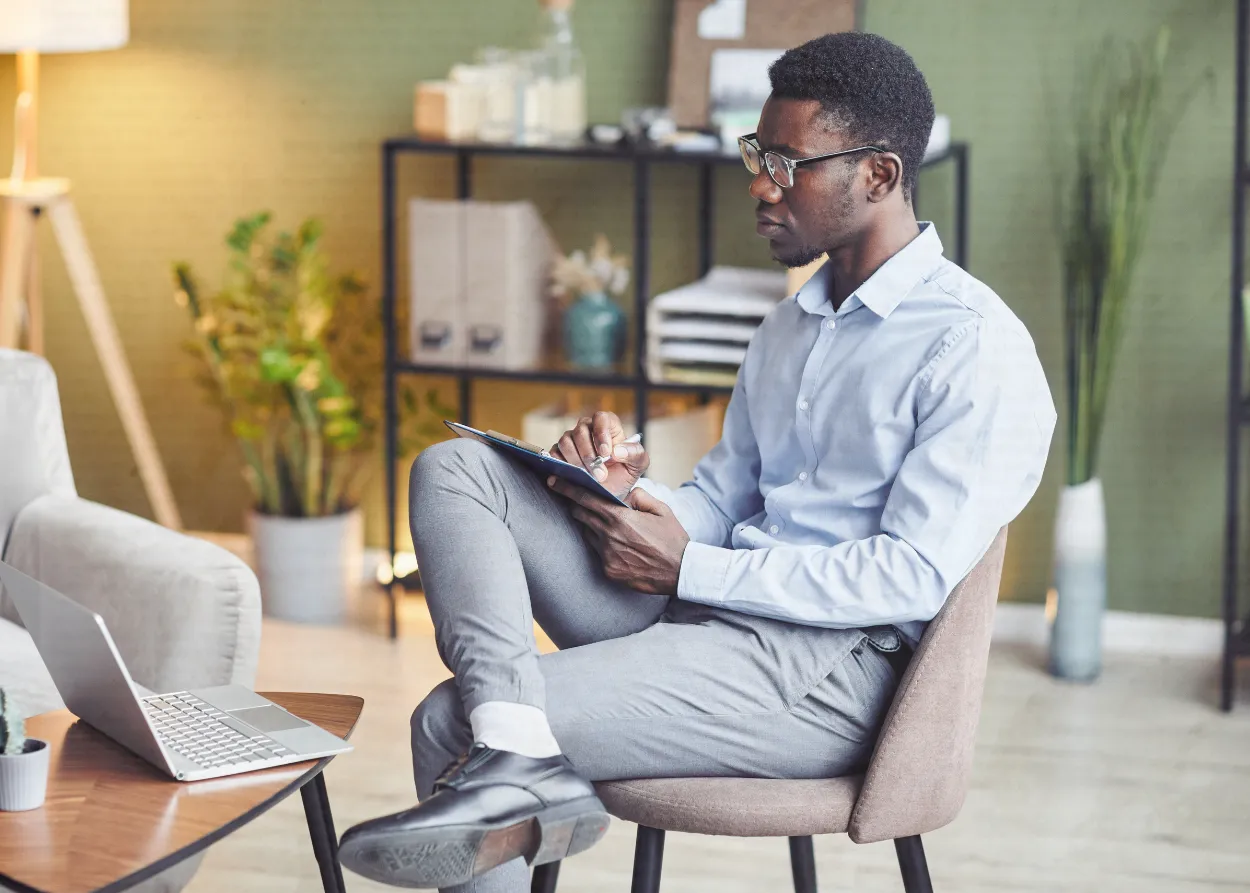 Male therapist sitting in his office on a video call. 