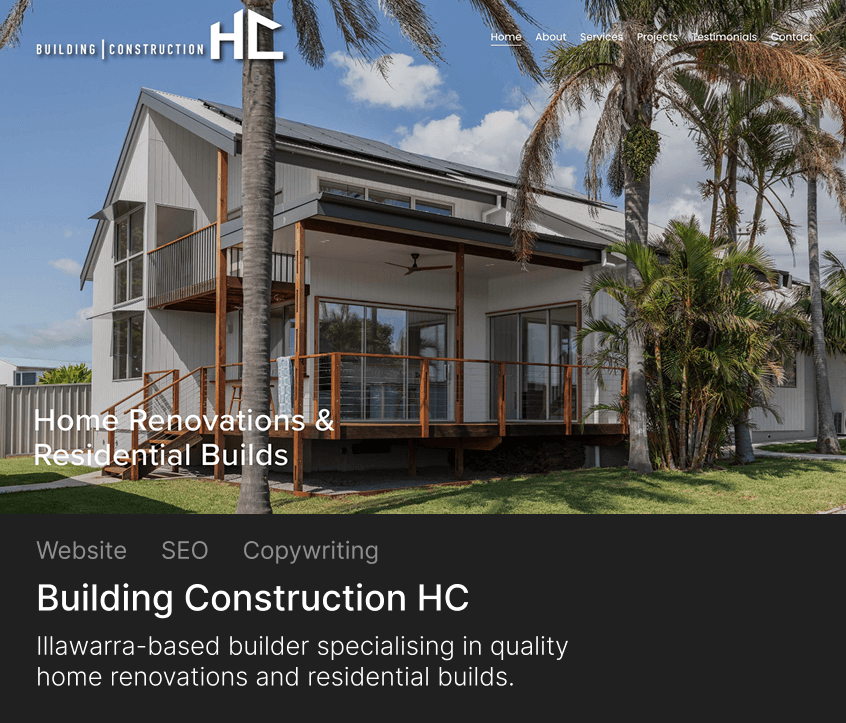 Modern two-story house with large balcony and wooden railings surrounded by palm trees and lawn under blue sky.