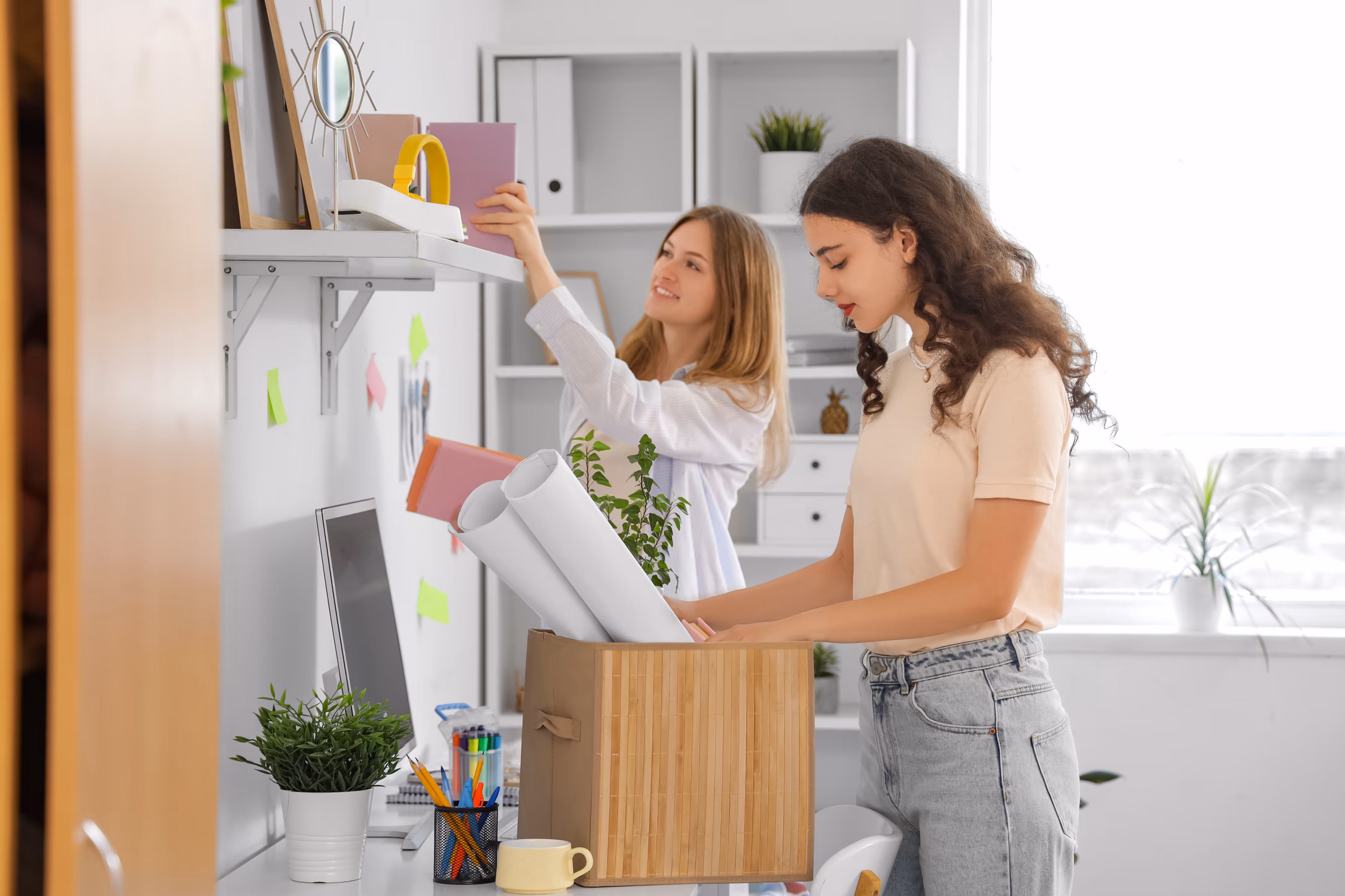 Two female students organizing and unpacking items in a shared apartment, showcasing the collaborative living and ample space at ArtHaus Telegraph in Berkeley, CA.
