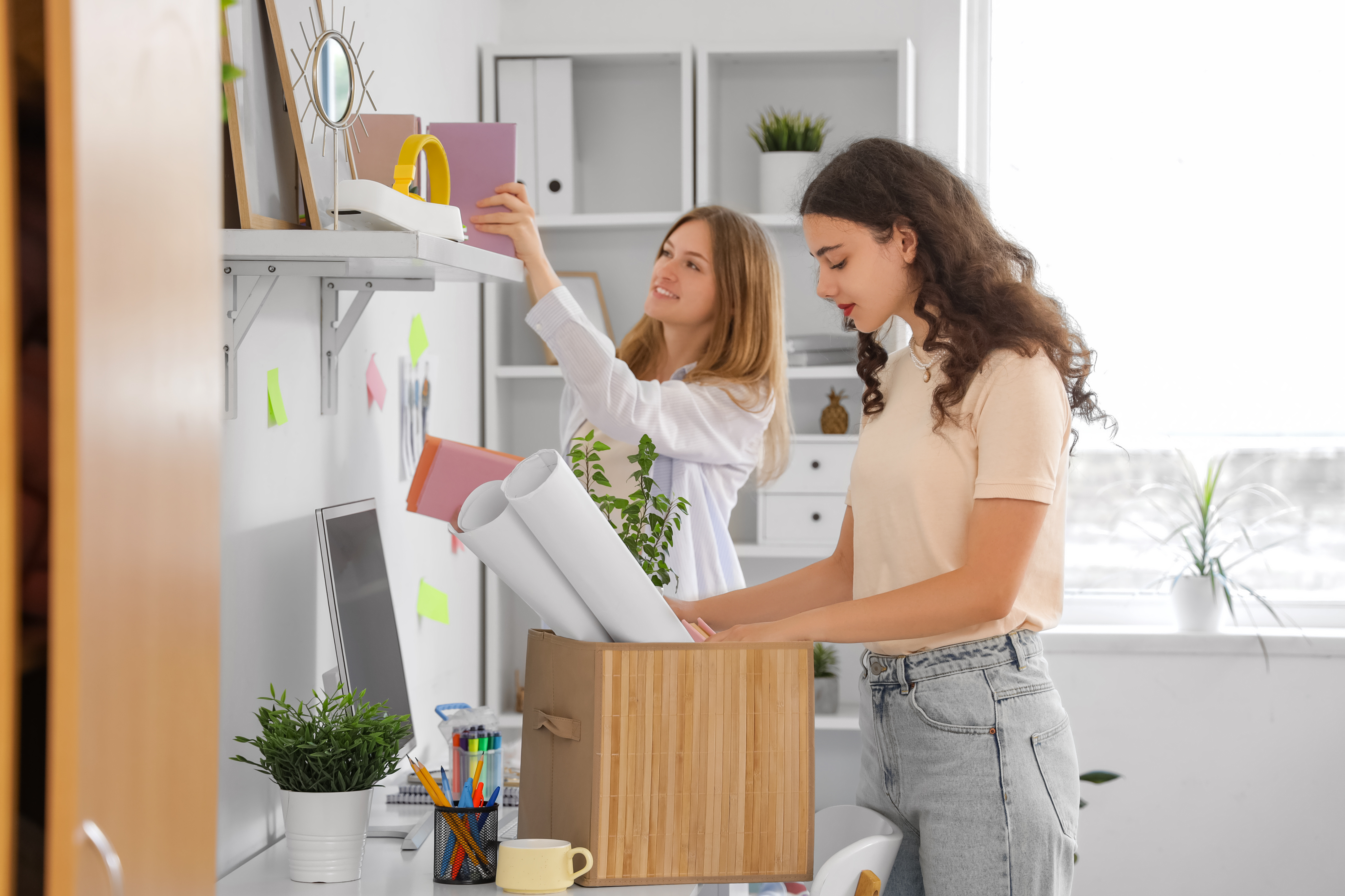 Two female students organizing and unpacking items in a shared apartment, showcasing the collaborative living and ample space at ArtHaus Telegraph in Berkeley, CA.