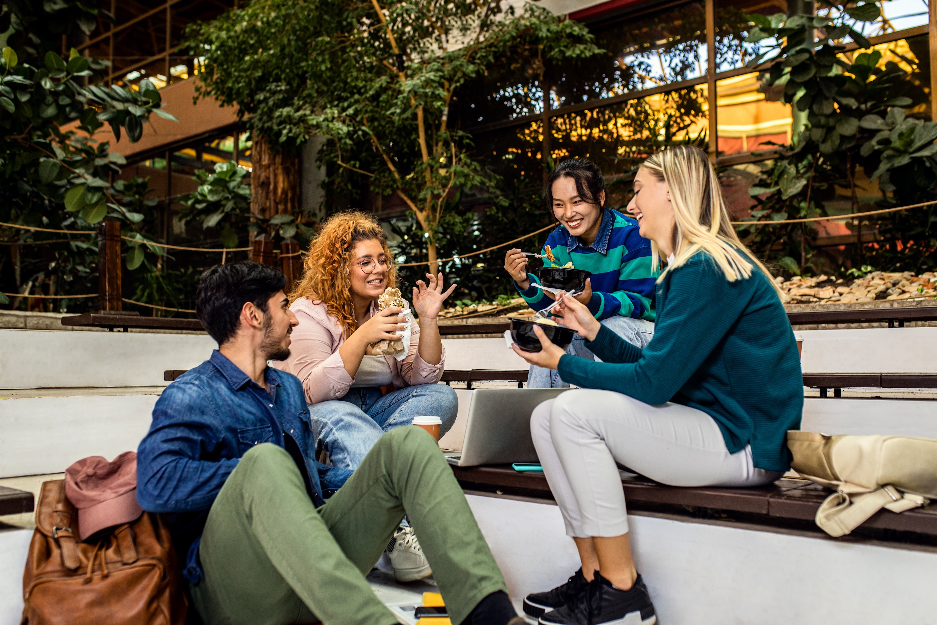 A group of residents sharing a meal and conversation on tiered outdoor seating, highlighting the nearby local spaces near ArtHaus Telegraph in Berkeley, CA.