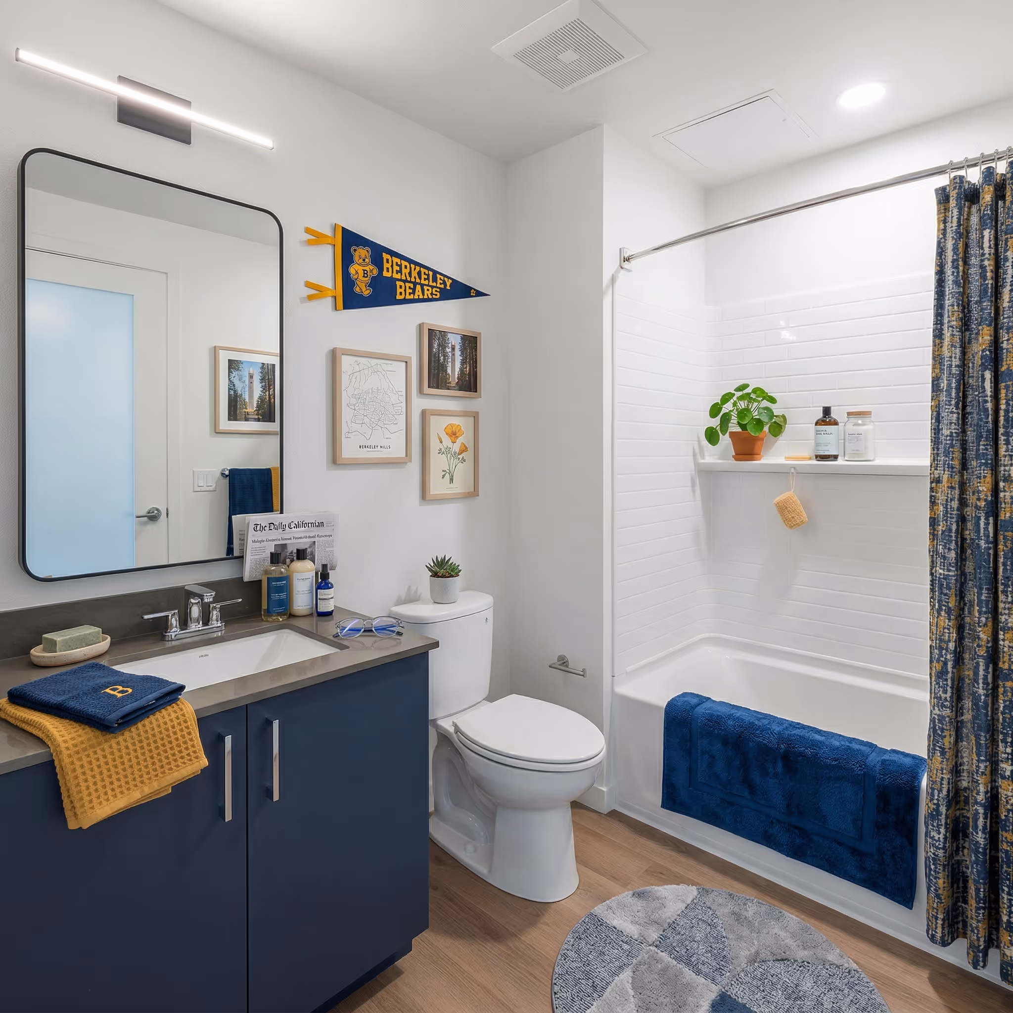Apartment bathroom featuring a vanity with blue cabinetry, a framed mirror, and a white shower/tub with shower curtain