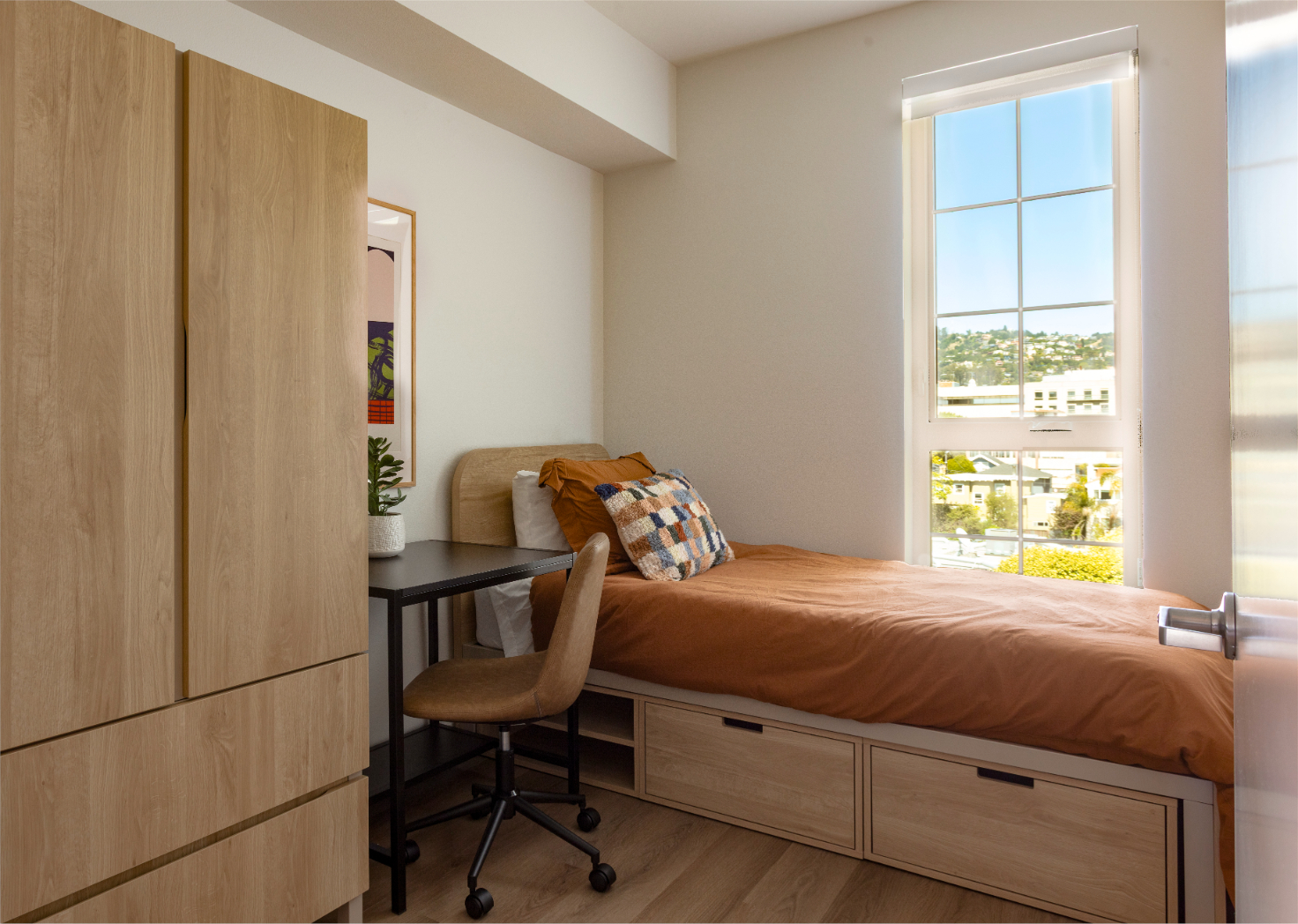 Apartment bedroom with desk and posters at ArtHaus Telegraph in Berkeley, CA.
