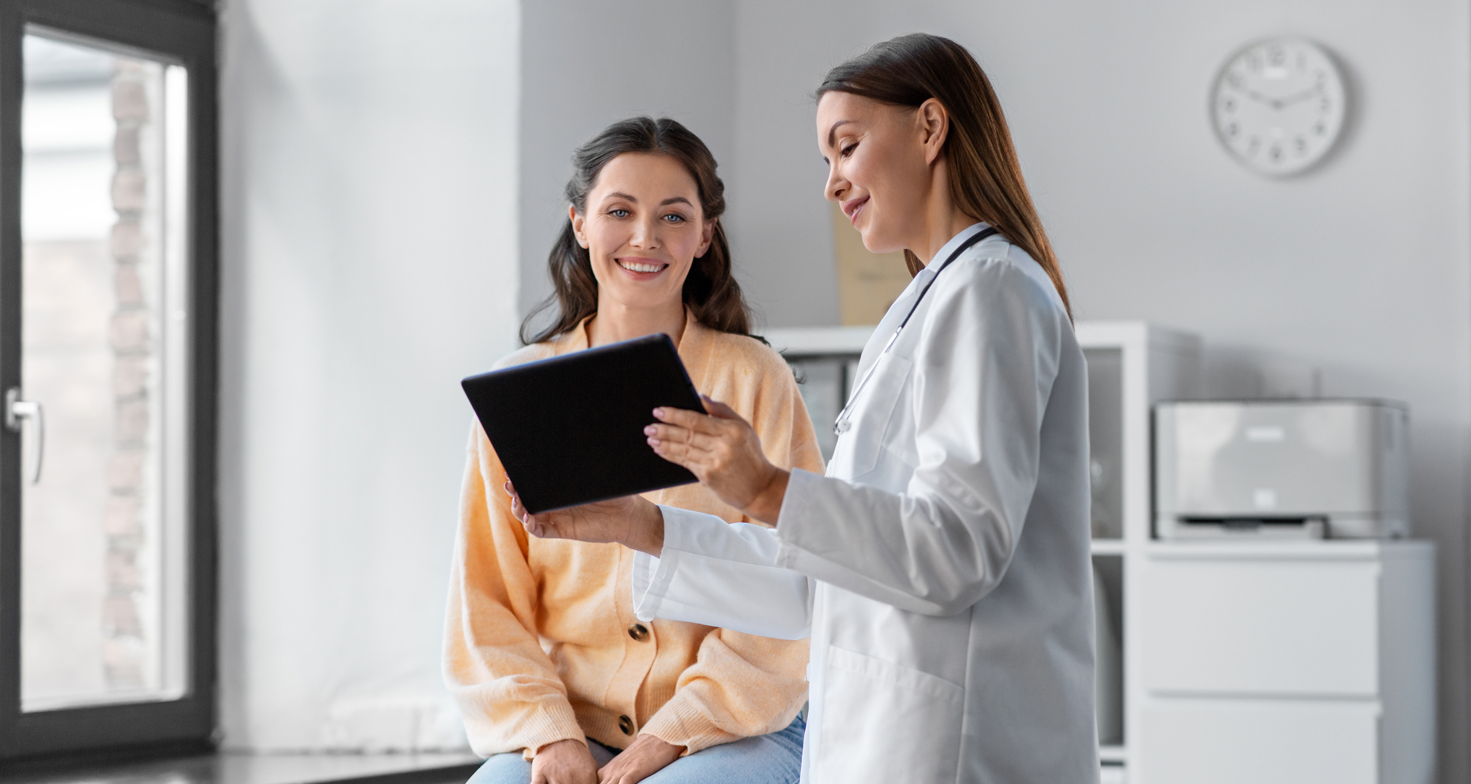 Woman speaking with a physician who is listening intently during a routine checkup, highlighting personalized women's healthcare from the best primary doctor in Great Neck, NY.