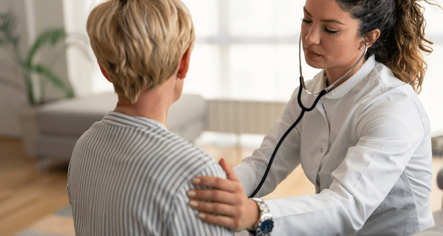 Concierge doctor performing a routine health check on a patient during a home visit, representing personalized care from the best primary care doctor in Great Neck, NY.