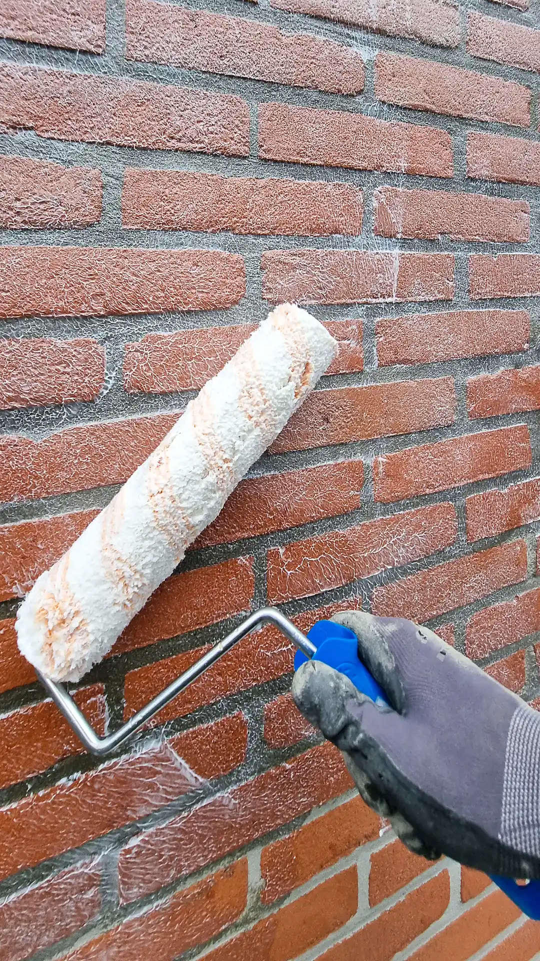 Behandeling van de gevel met de roller van dichtbij