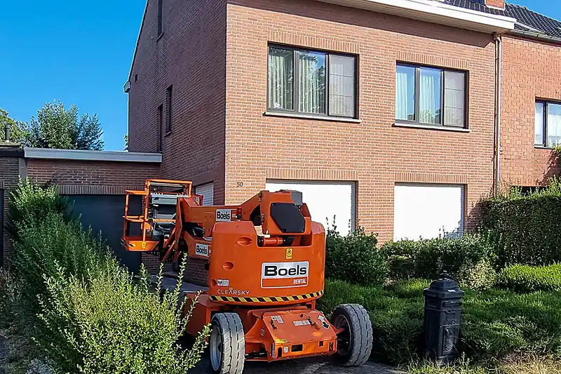Hoogwerker opgesteld op de oprit voor de gevelwerken