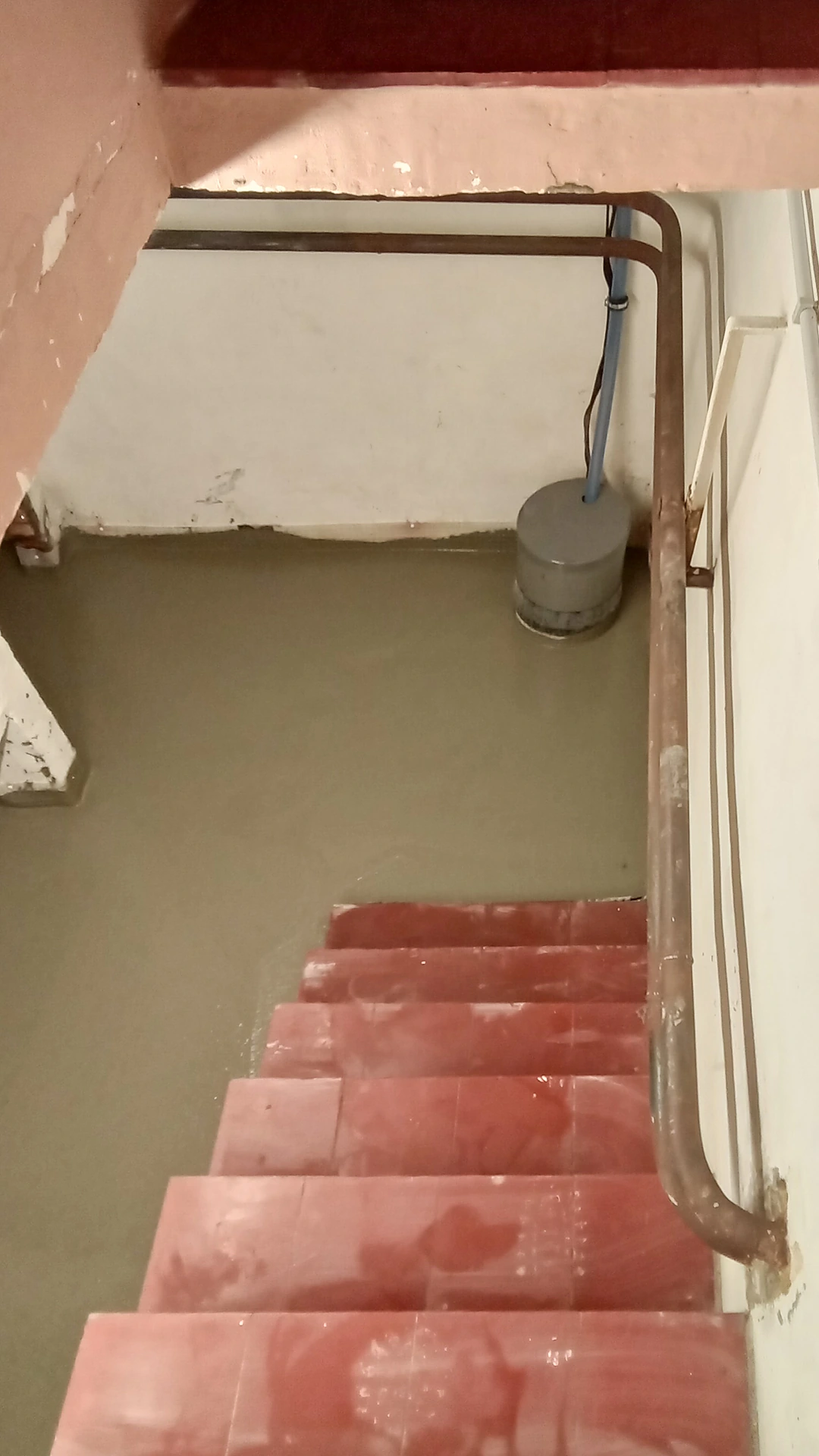 De rode keldertrap met de nieuwe betonvloer