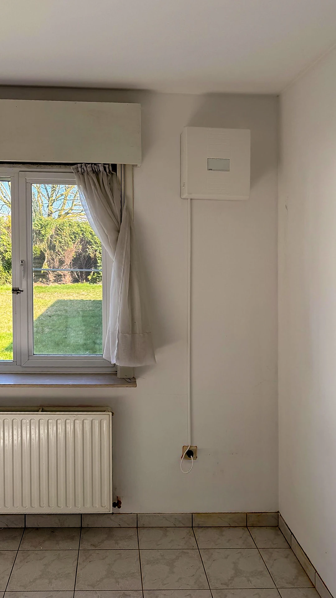 De kamer met de geplaatste ventilatie-unit naast het venster