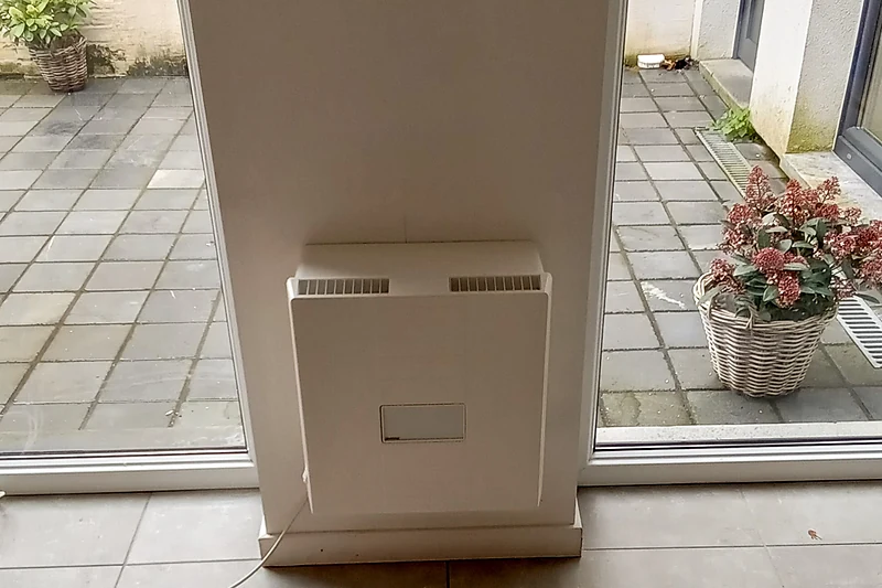 Meltem-ventilatie-unit op de wand tussen de glasdeuren naar het terras