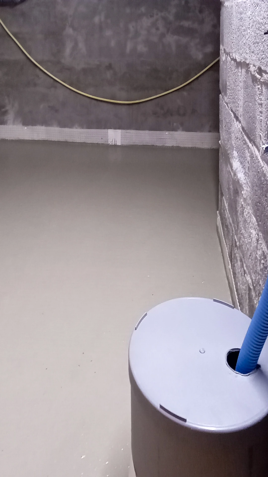 Pompputdeksel dat boven de verse betonvloer uitsteekt