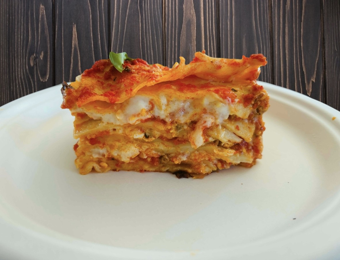 Burger with fried fries on black plate with sauce on the side