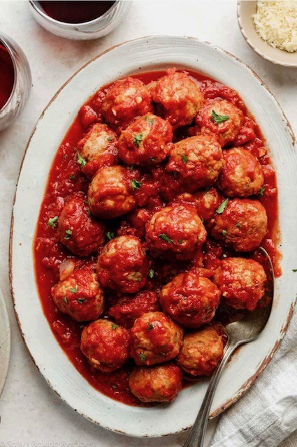 Burger with fried fries on black plate with sauce on the side