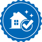 Icon of a house with a checkmark and sparkles inside a blue circle, symbolizing home approval or cleanliness.