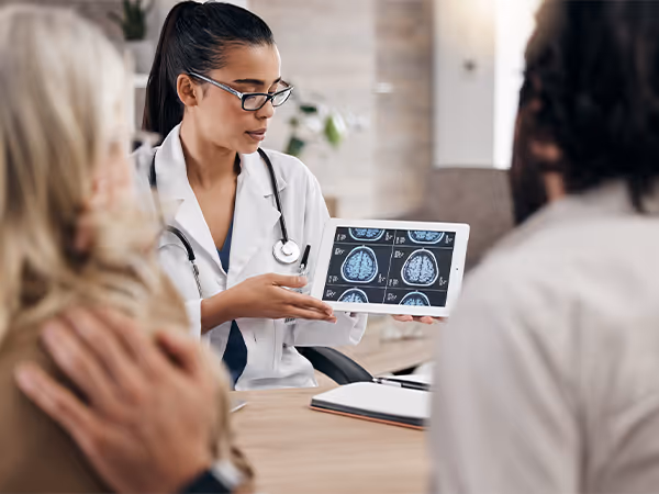 Doctor going over brain scans with two patients 