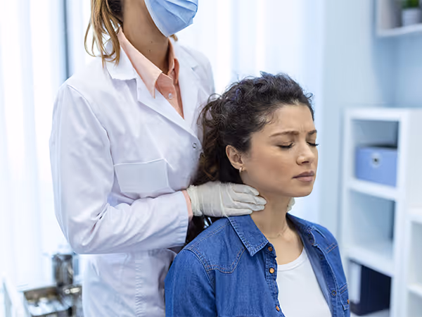 doctor examining patient's neck for pain