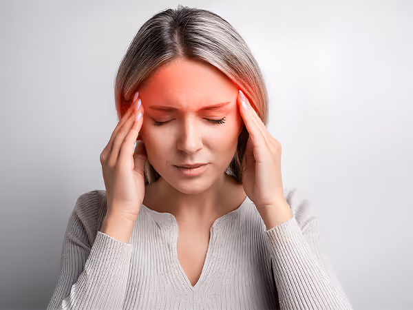 woman rubbing the temples of her head due to a concussion
