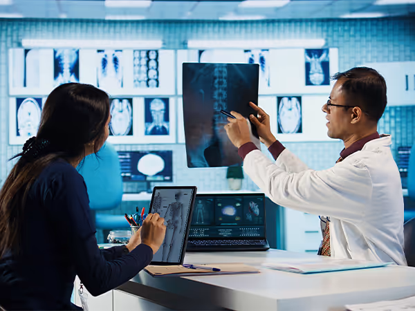 doctor looking at x-ray with patient of back