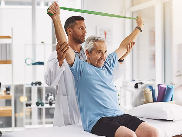 Doctor helping older patient with strength training