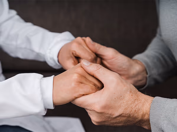 a doctor holding a pair of patient's hands