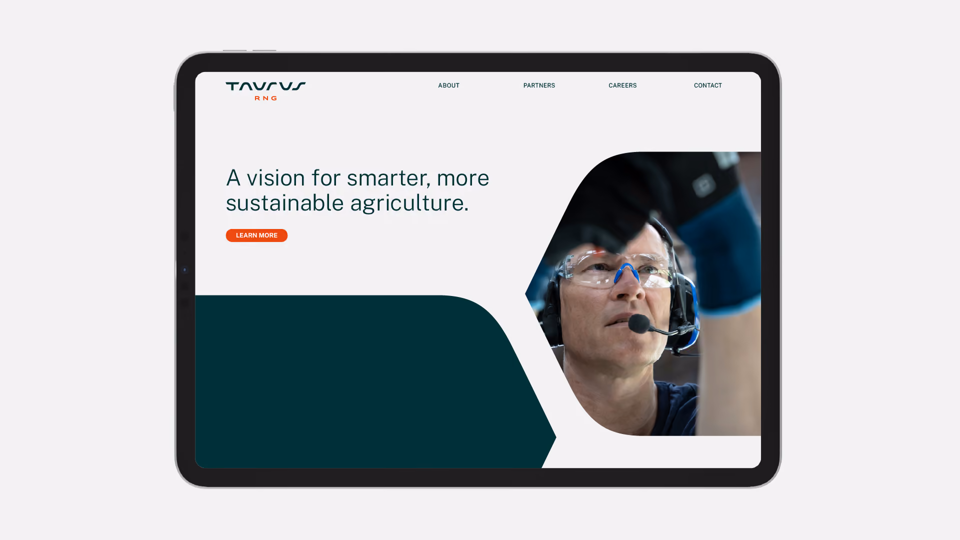 Tablet screen showing a webpage for Taurus RNG with the tagline 'A vision for smarter, more sustainable agriculture' and a learn more button, alongside a photo of a person wearing safety glasses and a headset working with machinery.