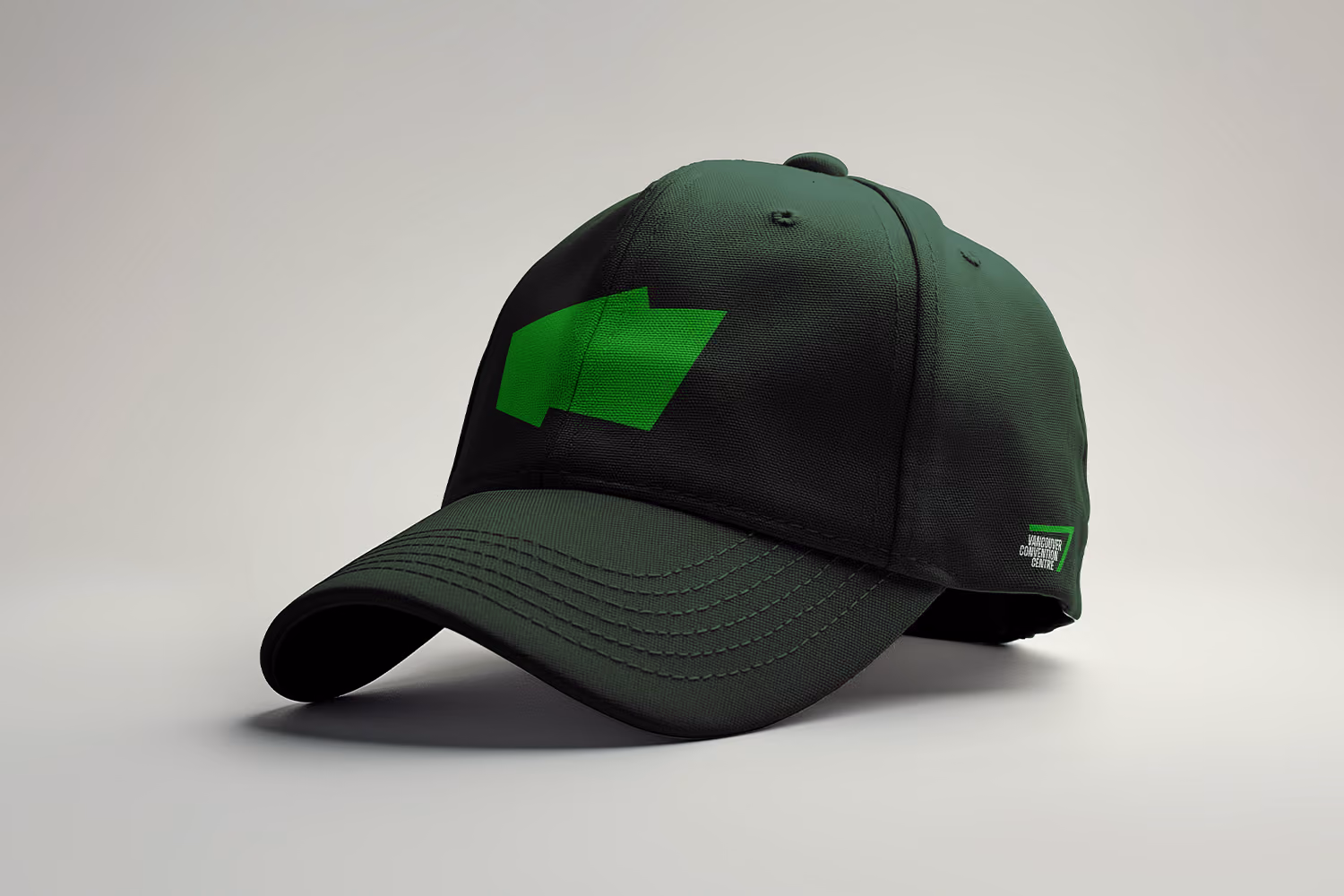 Dark green baseball cap with a green sharp shape on the front and the Vancouver Convention Centre logo on the side.