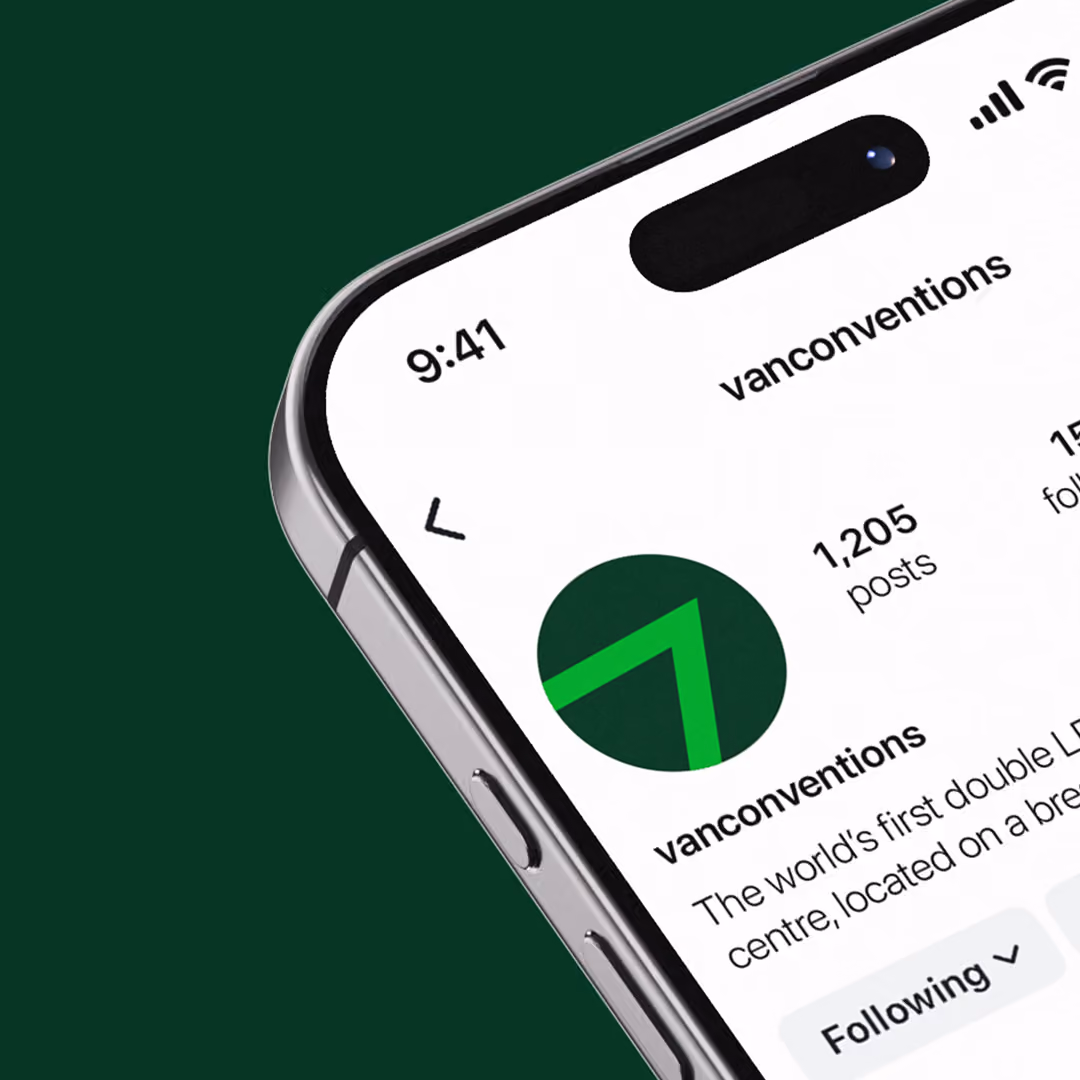 Close-up of a smartphone screen showing the Instagram profile of 'vanconventions' with 1,205 posts and a green arrow logo on a dark background.