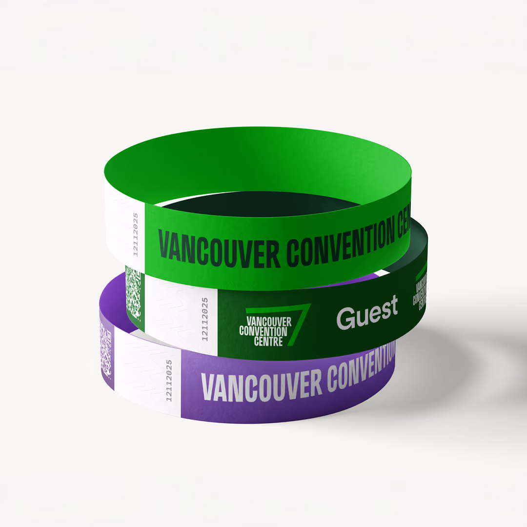 Stack of green and purple wristbands with 'Vancouver Convention Centre' wordmark and a logo, some marked 'Guest' and including QR codes and serial numbers.