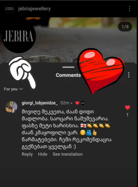 Instagram comment in Georgian with heart and hand pointing emoji overlay on a blurred background.