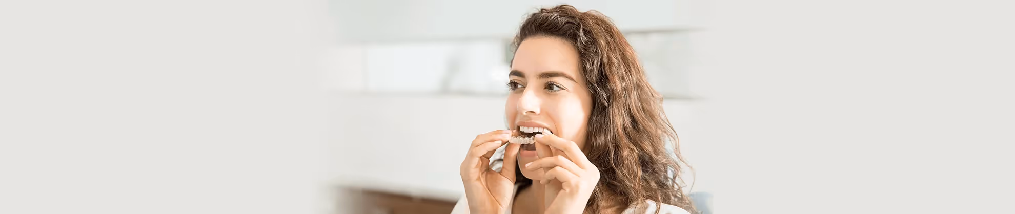 woman putting her clear aligners on