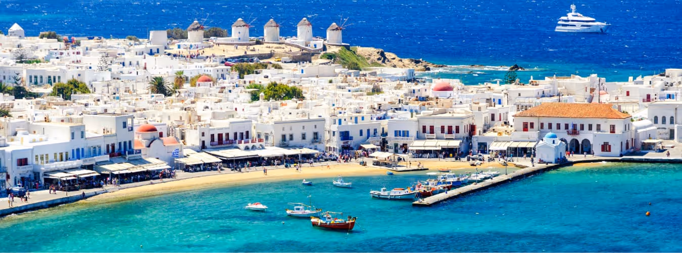 Mykonos Windmühlen und weiße Häuser mit türkisfarbenem Meer und Booten