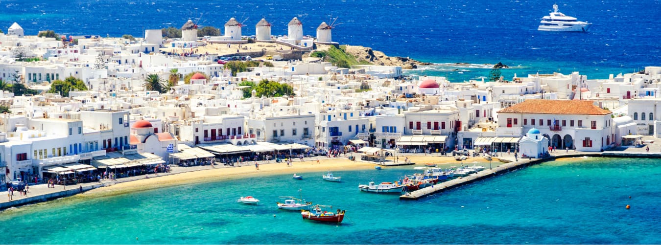 Mykonos Windmühlen und weiße Häuser mit türkisfarbenem Meer und Booten