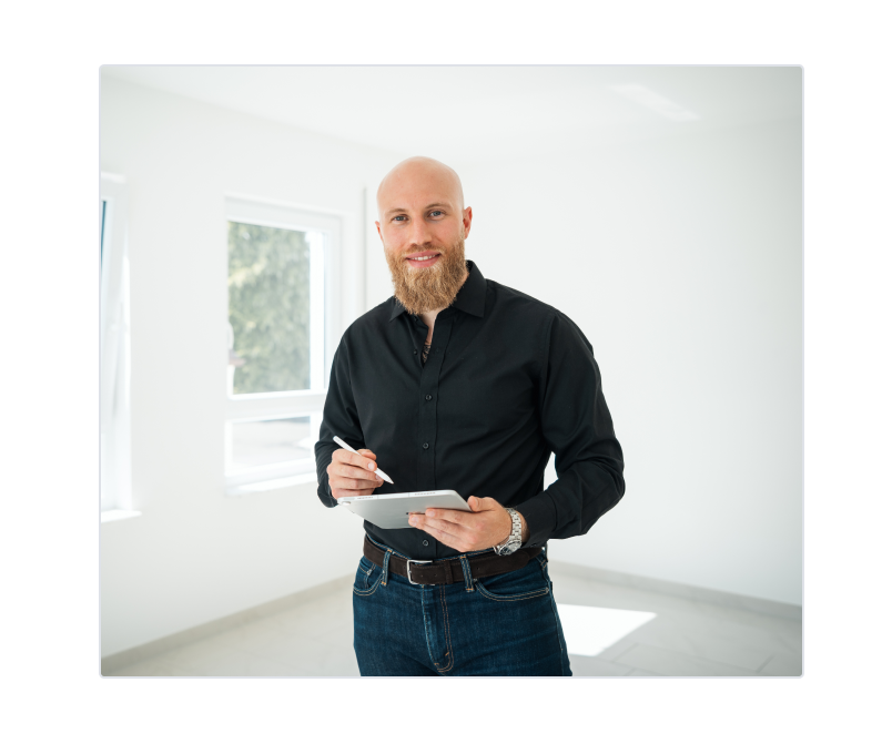 Professioneller Immobilienmakler mit Tablet in hellem Büroraum