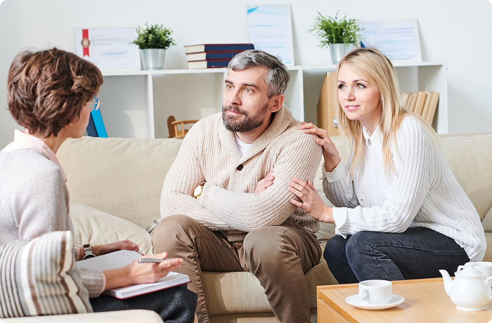 Family of three sitting together in therapy session