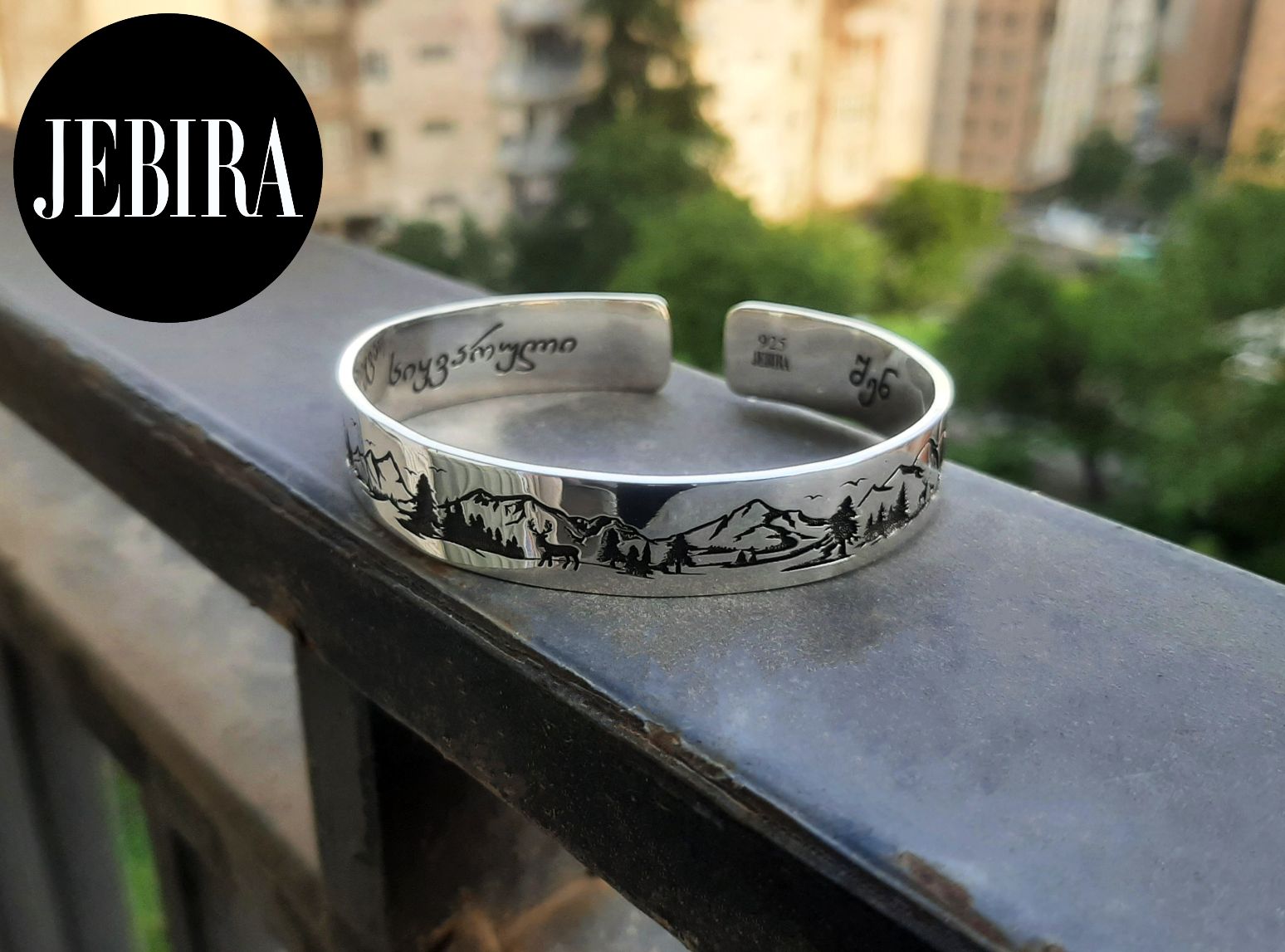 ვერცხლის სამაჯური ბუნების გრავირებით რომელზეც გამოსახულია მთები ირმები ხეები და ნავები