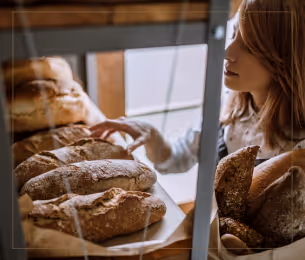 Mulher olhando para vitrine de pães