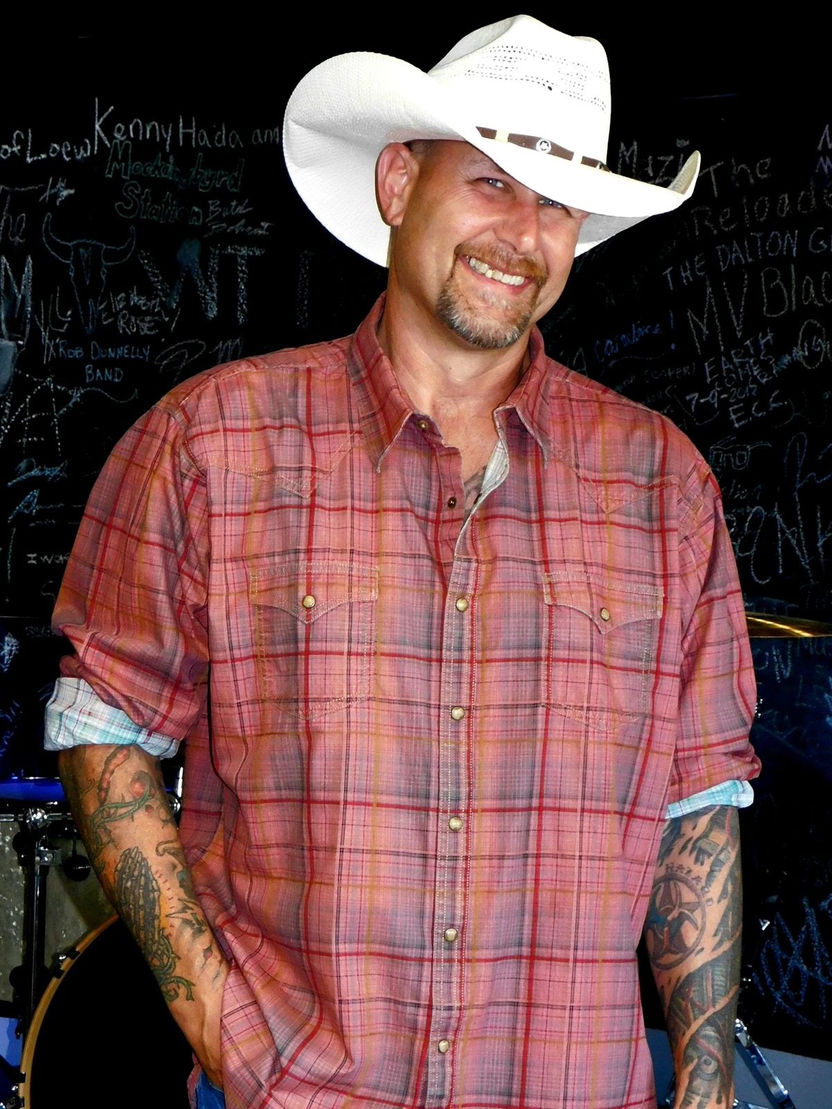Portrait image of man in cowboy hat and button down shirt.