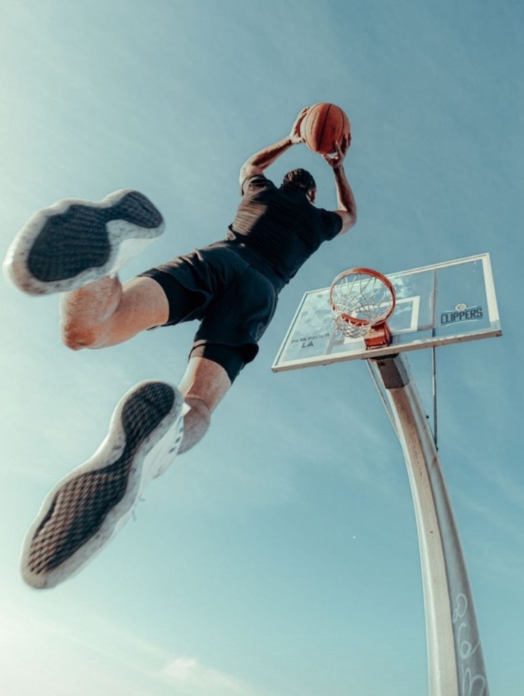 Athlete going up to dunk.