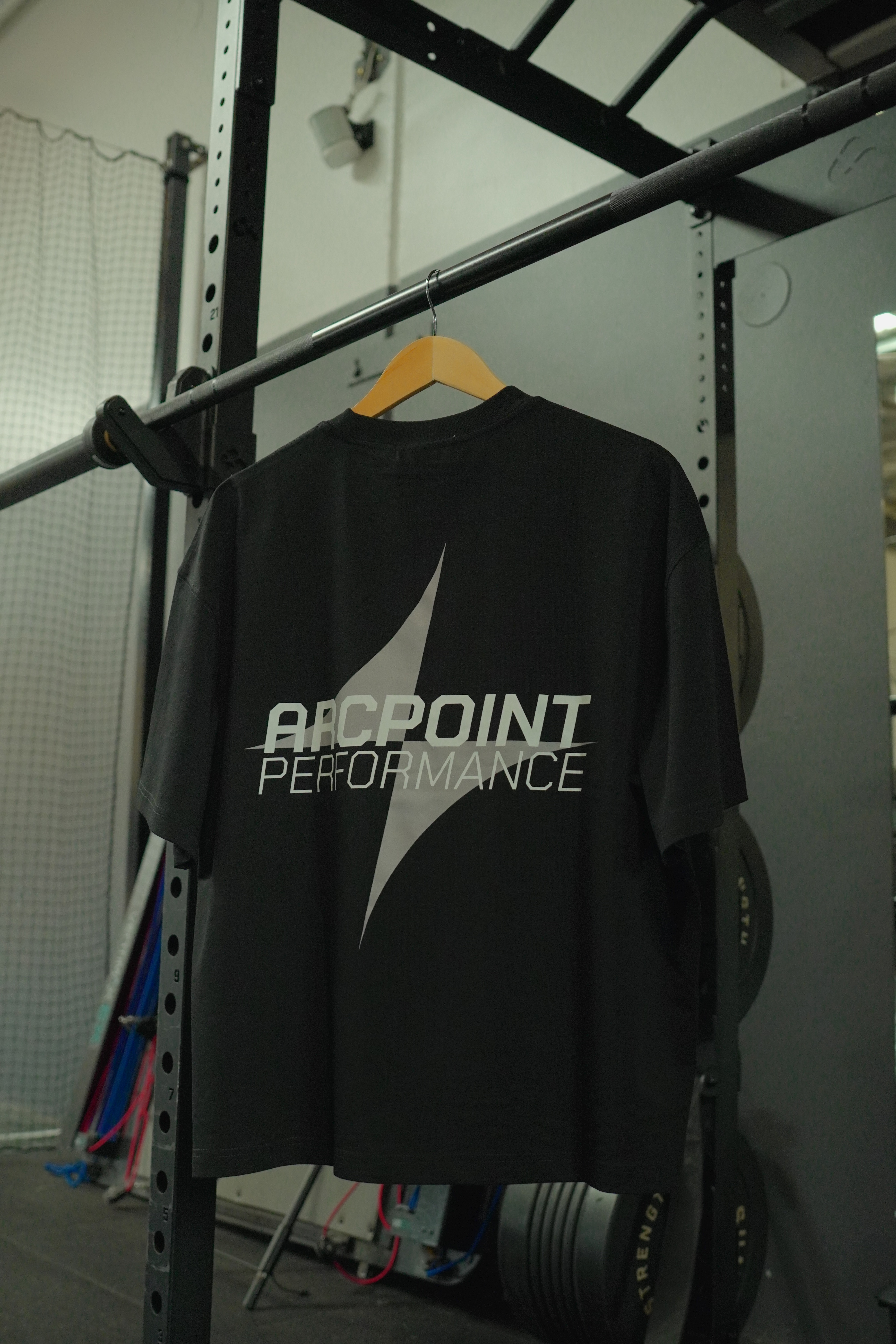 Black tank top hanging on a hanger with reflective text 'AP' and Arc logo.