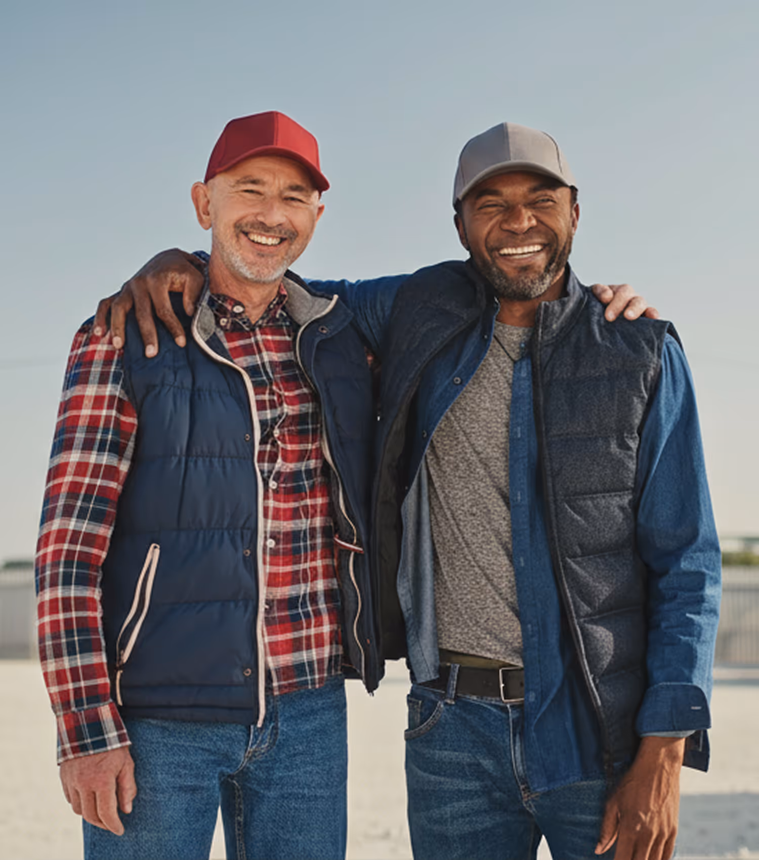 Two people sitting at a table looking at a laptop, one person pointing at the screen.
