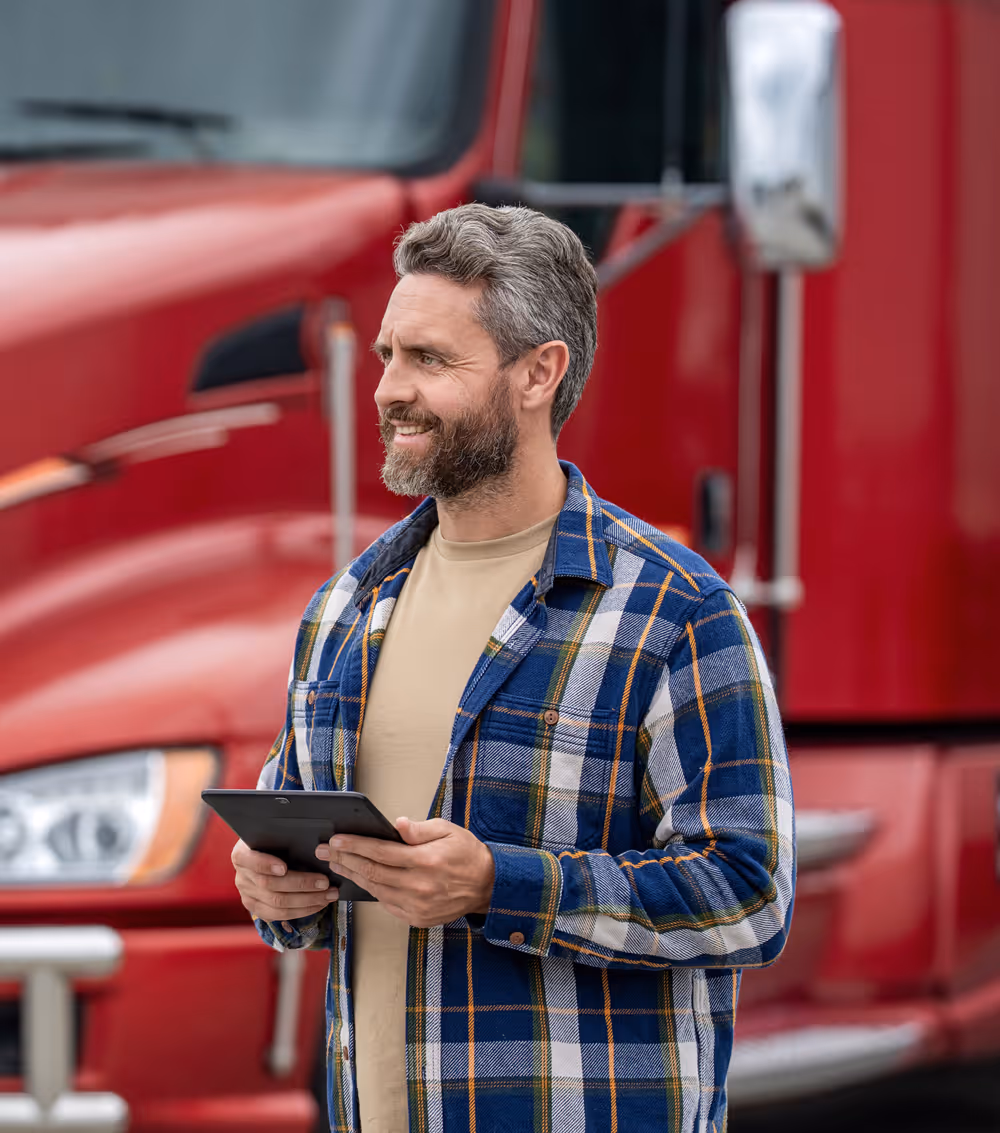 Two people sitting at a table looking at a laptop, one person pointing at the screen.