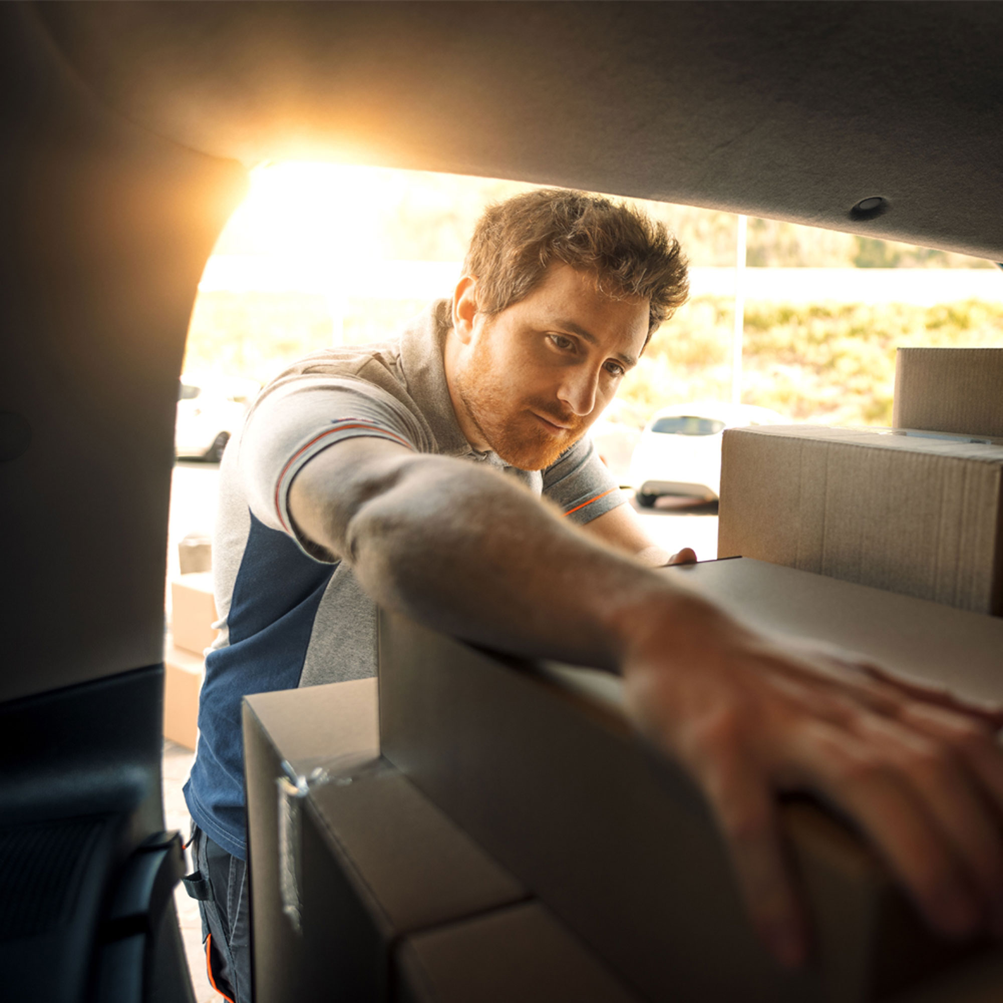 Two people sitting at a table looking at a laptop, one person pointing at the screen.