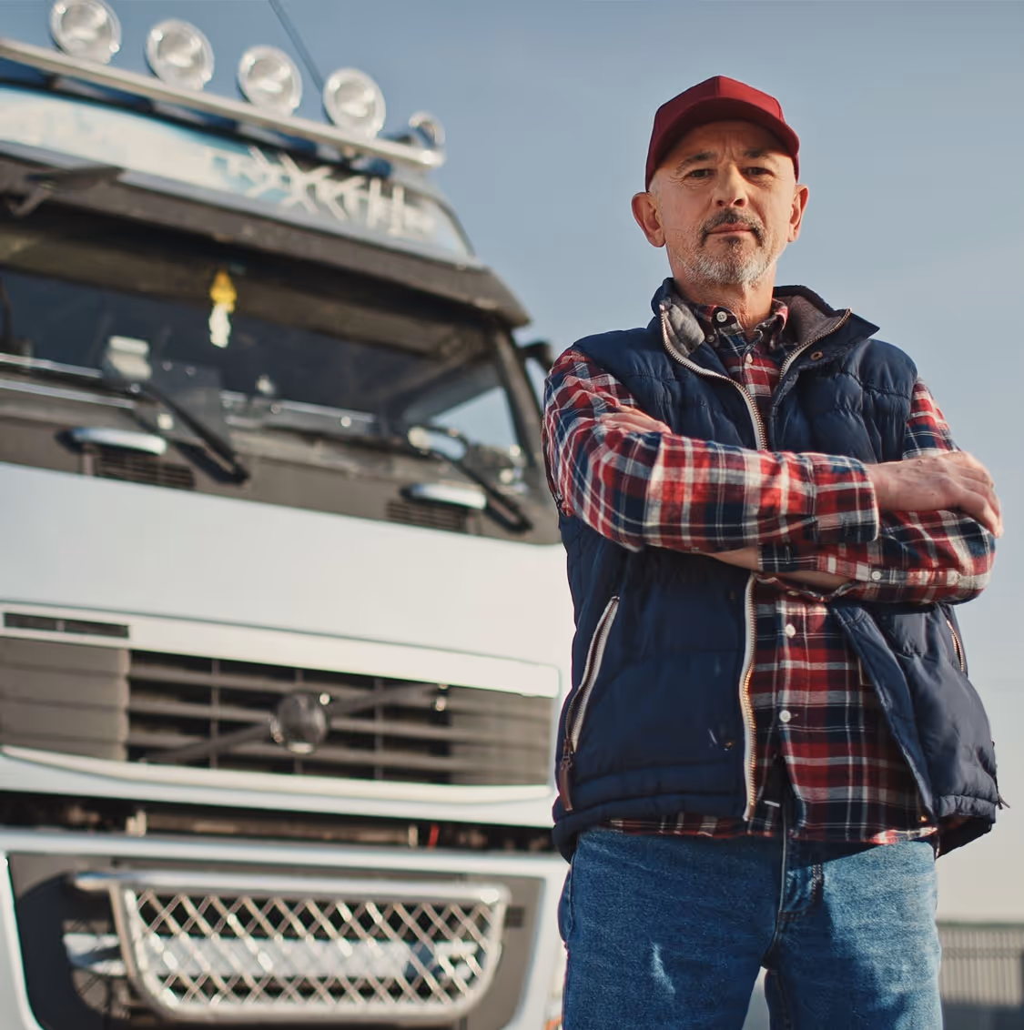 Two people sitting at a table looking at a laptop, one person pointing at the screen.