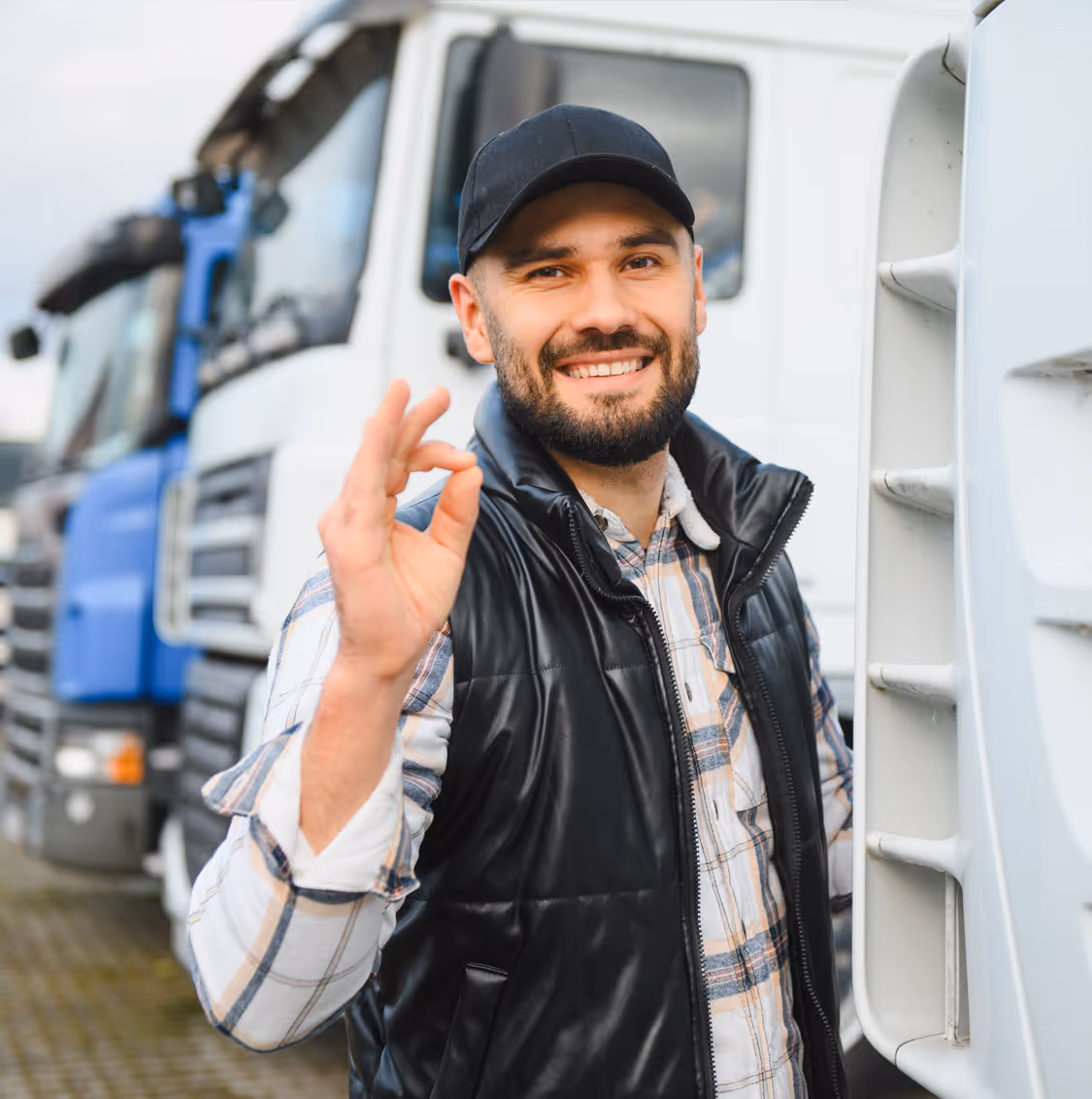 Two people sitting at a table looking at a laptop, one person pointing at the screen.