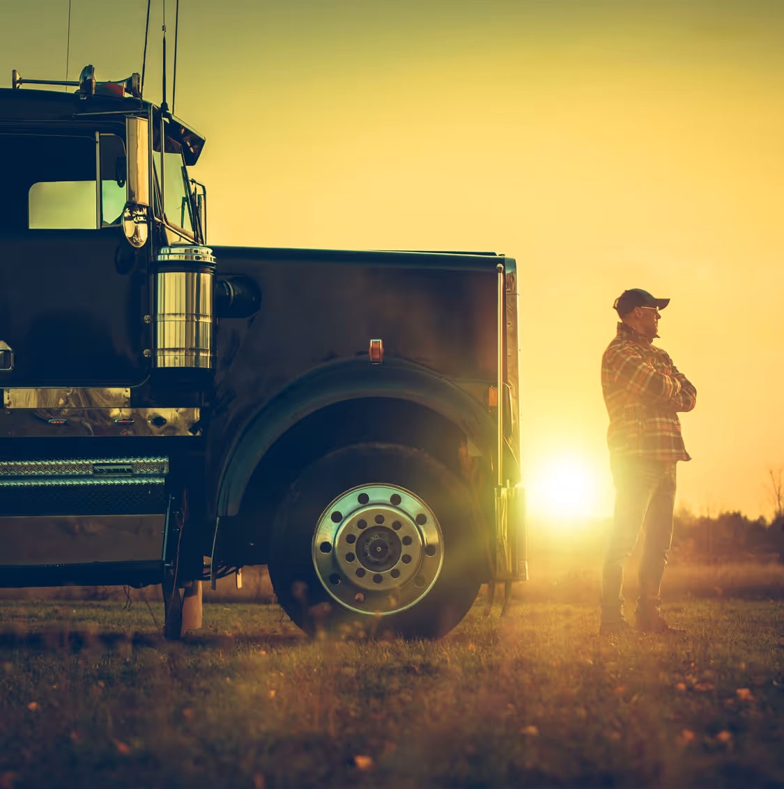 Two people sitting at a table looking at a laptop, one person pointing at the screen.